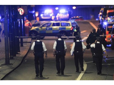 Police officers walk at the scene of an apparent terror attack on London Bridge.