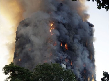 Smoke and flames rise from a building on fire in London, Wednesday, June 14, 2017. Metropolitan Police in London say they're continuing to evacuate people from a massive apartment fire in west London. The fire has been burning for more than three hours and stretches from the second to the 27th floor of the building.