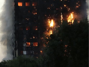 Smoke and flames rise from a building on fire in London, Wednesday, June 14, 2017. Metropolitan Police in London say they're continuing to evacuate people from a massive apartment fire in west London. The fire has been burning for more than three hours and stretches from the second to the 27th floor of the building.