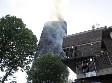 Firefighters in place as they battle a massive fire that raged in a 27-floor high-rise apartment building in London, Wednesday, June 14, 2017. Fire swept through a high-rise apartment building in west London early Wednesday, killing an unknown number of people and sending more than 50 people to area hospitals.