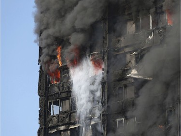 Smoke billows from a high-rise apartment building on fire in west London Wednesday, June 14, 2017. Fire swept through the high-rise apartment building early Wednesday, sending dozens people to area hospitals.