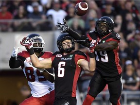 Redblacks defensive backs Imoan Claiborne, right, and Antoine Pruneau foil a pass into the end-zone for Stampeders receiver DaVaris Daniels.