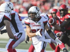 Redblacks receiver Josh Stangby (87) flips the football back to slotback Brad Sinopoli, left, on a flea-flicker play in the first half of Thursday's game. Sinopoli's pass for teammate Greg Ellingson far down the field fell incomplete. THE CANADIAN PRESS/Mike Ridewood