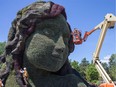 Gardeners use a cherry-picker to apply finishing touches to the massive Mother Earth (Terre Mère) sculpture at the MosaïCanada display in Gatineau.