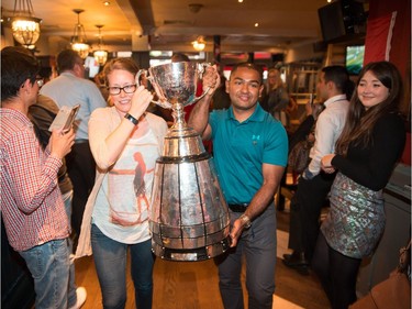Master Seaman Clarisa Smallwood of Mount Pearl, N.L., and Master Seaman Kyaw San Myint of Surrey, B.C., carry the Grey Cup into the Maple Leaf Sports Bar and Grill in central London on Friday. Former CFL quarterback Henry Burris accompanied the Canadian Football League's championship trophy to London as part of Canada 150 activities there. Jim Ross/CFL