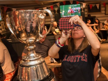 Martyne Martimbeault of Montreal takes a photo with the Grey Cup inside the Maple Leaf Pub. Jim Ross/CFL