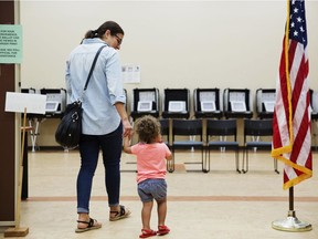 Melissa Painter walks with her one year-old daughter, Elle, to vote in Georgia's 6th Congressional District special election at a polling site in Sandy Springs, Ga., Tuesday, June 20, 2017.