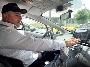 George Chamoun, chair of the Capital Taxi unit of the taxi union, shows off the driver tablet that displays the information of customers who order rides through a new app.