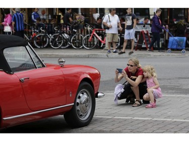 Stylish and sporty Italian cars were parked along the streets of Little Italy for people of all ages to admire and photograph on Saturday, June 17. Caryn Darlington and daughter Amber compose a shot of a vintage Alfa Romeo.(David Kawai)

126926
David Kawai
