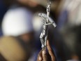 A man holds a crucifix during a Pentecost vigil prayer lead by Pope Francis at Rome's Circus Maximus on June 3, 2017.