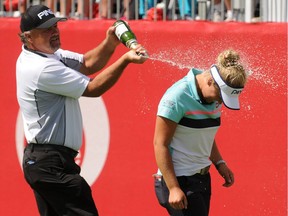 Dave Henderson, left, sprays his daughter Brooke Henderson, of Canada, with champagne after she won  after winning the Meijer LPGA Classic golf tournament at Blythefield Country Club. Sunday, June 18, 2017, in Grand Rapids, Mich.. (Cory Olsen/The Grand Rapids Press via AP) ORG XMIT: MIGRA203

MANDATORY CREDIT
Cory Olsen, AP