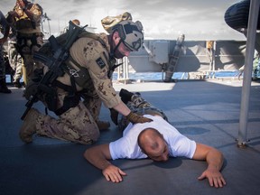Members of the Maritime Tactical Operations Group (MTOG) search Australian Navy personnel as part of a tactical exercise with Her Majesty's Australian Ship BALLARAT during POSEIDON CUTLASS, on June 9, 2017. Photo: Cpl Carbe Orellana, MARPAC Imaging Services.