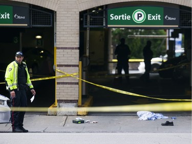 Ottawa Police and the SIU are investigating two fatalities in Ottawa's downtown Saturday June 3, 2017. An Ottawa Police officer stands in front of a parking garage on Murray street guarding the scene.  Ashley Fraser/Postmedia