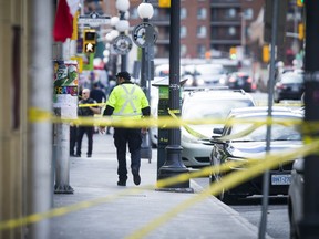 A police officer on Dalhousie Street between Murray and Clarence streets works at the scene of a multiple shooting on Saturday.