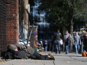 A man sleeps near the Salvation Army on George Street in Ottawa last fall. Will a new proposed social services 'hub' proposed for Vanier help or simply inflame community anger?