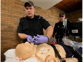 Paramedics Richard White and Colin Stiff demonstrate how they care for an overdosing person with nalaxone.