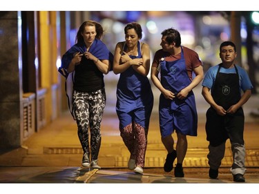 People walk away just before midnight from inside a police cordon after an attack in London.