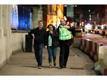 A police officer escorts members of the public to safety at London Bridge.