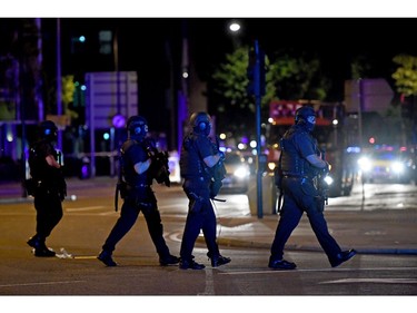 Armed police walk down Borough High Street towards Vauxhall.