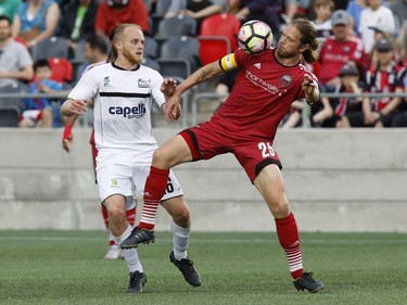 Fury FC captain Lance Rozeboom, right, tries to corral the ball against the Islanders' Jake Bond.