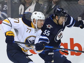 Sabres defenceman Dmitry Kulikov, left, ties up Jets centre Mark Scheifele during a game at Winnipeg on Oct. 30. It's believed the Senators have shown interest in trying to sign Kulikov. Brian Donogh/Postmedia