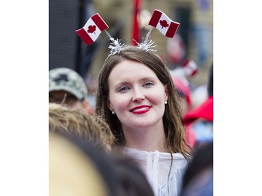 A woman smiles while watching performers on the centre stage on the front lawn of Parliament Hill during Canada Day celebrations in downtown Ottawa Saturday, July 1, 2017.