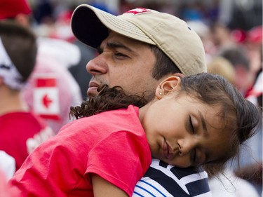 A girl sleeps on her father's shoulders during Canada Day celebrations on Parliament Hill in downtown Ottawa Saturday, July 1, 2017.