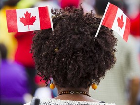 A woman watches the morning show on Parliament Hill during Canada Day celebrations in downtown Ottawa Saturday, July 1, 2017.
