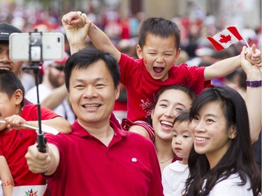 Thomas Yiu, centre, takes a photo of members of his family and friends on Sussex St. during Canada Day celebrations in downtown Ottawa Saturday, July 1, 2017.