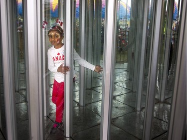 People didn't let the weather stop them from heading out to celebrate Canada Day in Barrhaven at Clarke Fields Saturday July 1, 2017. Seven-year-old Kishana Rajkumar makes her way through one of the midway attractions.