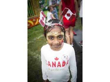 People didn't let the weather stop them from heading out to celebrate Canada Day in Barrhaven at Clarke Fields Saturday July 1, 2017. Seven-year-old Kishana Rajkumar shows off her festive face paint and headband.