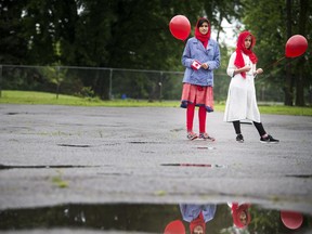 To celebrate Canada Day the Ahmadiyya Muslim Jama'at Ottawa organized a Canada Day Festival at Baitun Naseer Mosque in Cumberland Saturday July 1, 2017. L-R 13-year-old Aneeqah Mehmood and 12-year-old Areeka Noor  stand with balloons during the speeches Saturday.