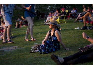 Kelley Pyrik sits on the hill watching the sun set at RBC Bluesfest on Saturday.  Ashley Fraser/Postmedia