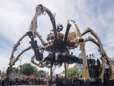 Kumo, the spider, chases Long Ma, the horse-dragon, not pictured, away from the National Gallery during a La Machine performance Friday, July 28, 2017.