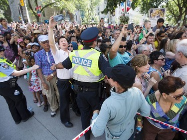 Police and volunteers push back the throng of spectators as Long Ma, the horse-dragon, walks outside the Supreme Court of Canada on Sunday. Darren Brown/Postmedia