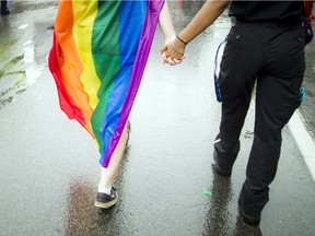 Two people walk at Capital Pride's 2016 parade. Ashley Fraser/Postmedia