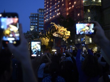 People raise their smartphones to take pictures of Long Ma, the horse-dragon, on Elgin Street during the La Machine performance in Ottawa on Saturday, July 29, 2017.
