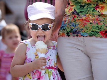 Anastasia Klimova, 3, clings to her grandmother's hip while cooling off with some ice cream at the Ukrainian festival.