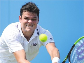 Canada&#039;s Milos Raonic returns against Thanasi Kokkinakis during their match at the Aegon Championships on Tuesday in London. Raonic lost to the 698th-ranked Aussie 7-6 (5), 7-6 (8).