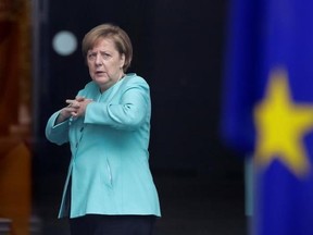 German Chancellor Angela Merkel stands behind a European flag as she waits for the arrival of Chinese President Xi Jinping at the chancellery in Berlin, Germany, Wednesday, July 5, 2017. Xi is in Germany to open an Panda enclosure in Berlin and to attend the G-20 summit in Hamburg later the week. (AP Photo/Markus Schreiber)