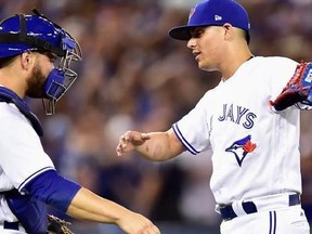 Toronto Blue Jays relief pitcher Roberto Osuna (54) celebrates with catcher Russell Martin (55) after closing out the ninth inning of American League MLB baseball action to beat the Houston Astros in Toronto on Thursday, July 6, 2017.