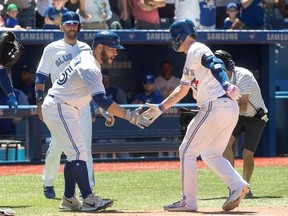 Toronto Blue Jays&#039; Russell Martin, left, congratulates teammate Josh Donaldson after he hit a three-run home run against the Houston Astros in the fifth inning of their American League MLB baseball game in Toronto on Saturday, July 8, 2017. THE CANADIAN PRESS/Fred Thornhill