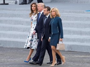 President Donald Trump, first lady Melania Trump, French President Emmanuel Macron, and and his wife Brigitte Macron, walk from the viewing stand a the conclusion of the Bastille Day parade on the Champs Elysees avenue in Paris, Friday, July 14, 2017. (AP Photo/Carolyn Kaster)