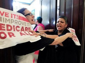 Protesters against the Republic health care proposals block the entrance to the office of Sen. Cory Gardner, R-Colo., at the Russell Senate Office building on Capitol Hill in Washington, Wednesday, July 19, 2017.