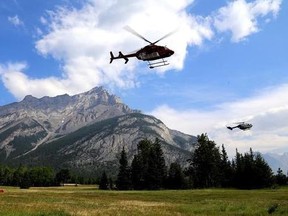 Helicopters are seen leaving a fire base for the Verdant Creek wildfire in an undated Parks Canada handout image. About 140 fires are currently burning in the province, and more than 3,500 square kilometres of land have been scorched by wildfires this year. THE CANADIAN PRESS/HO-Parks Canada, *MANDATORY CREDIT*