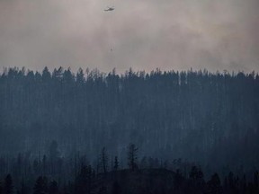 A helicopter is used to battle a wildfire burning on the top of a mountain near Ashcroft, B.C., on Monday, July 10, 2017. Officials are concerned strong winds today will spread wildfires that crews in British Columbia are struggling to contain.Environment Canada says wind gusts of about 50 kilometres per hour can be expected across the southern parts of the province including Williams Lake, Castlegar and Princeton.