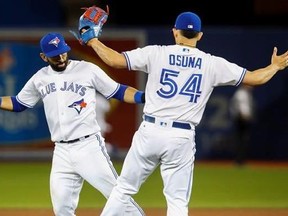 Toronto Blue Jays relief pitcher Roberto Osuna (54) and right fielder Jose Bautista celebrate defeating the Oakland Athletics following American League MLB baseball action in Toronto on Tuesday, July 25, 2017.