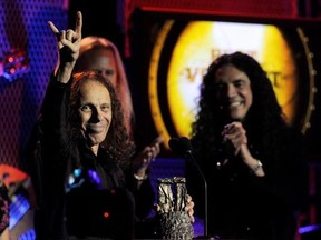 FILE - In this April 8, 2010, file photo, Ronnie James Dio, left, celebrates after receiving the Best Vocalist award at the second annual Revolver Golden Gods Awards in Los Angeles. Rolling Stone reported July 26, 2017, that Dio, who died in 2010, would tour again in hologram form. (AP Photo/Chris Pizzello, File)