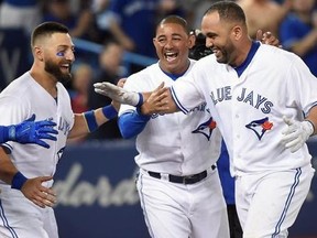 Toronto Blue Jays designated hitter Kendrys Morales, right, is congratulated by teammates Justin Smoak, left to right, Kevin Pillar and Ezequiel Carrera after hitting a walk-off solo home run during ninth inning American League MLB baseball against the Oakland Athletics in Toronto on Wednesday, July 26, 2017.