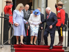 The offending touch: Governor General David Johnston assists the Queen on the steps outside Canada House. (David Sims/WENN.com)